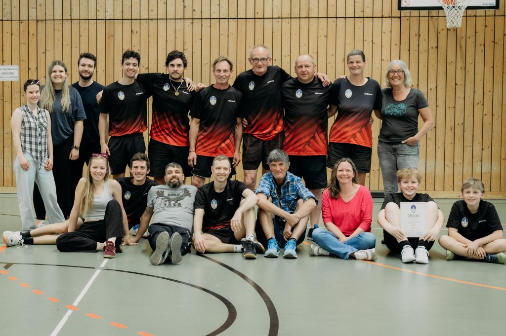 Ein Gruppenbild mit Männern und Frauen in einer Turnhalle